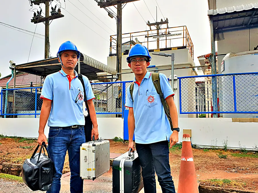 วิศวกรบริการ CG สองคนสวมหมวกนิรภัยถือกล่องเครื่องมือถึงหน้างานโรงงานลูกค้า