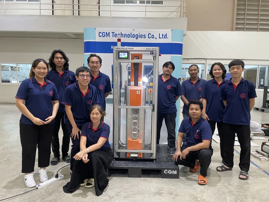 ทีมงาน CGM Technologies ยืนถ่ายภาพกับเครื่องทดสอบยางที่ผลิตเสร็จในโรงประกอบ