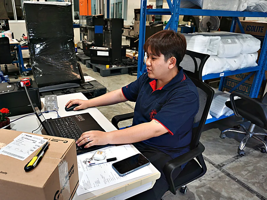 พนักงานจัดการเอกสารงานบริการบนแล็ปท็อปข้างพื้นที่ประกอบเครื่อง